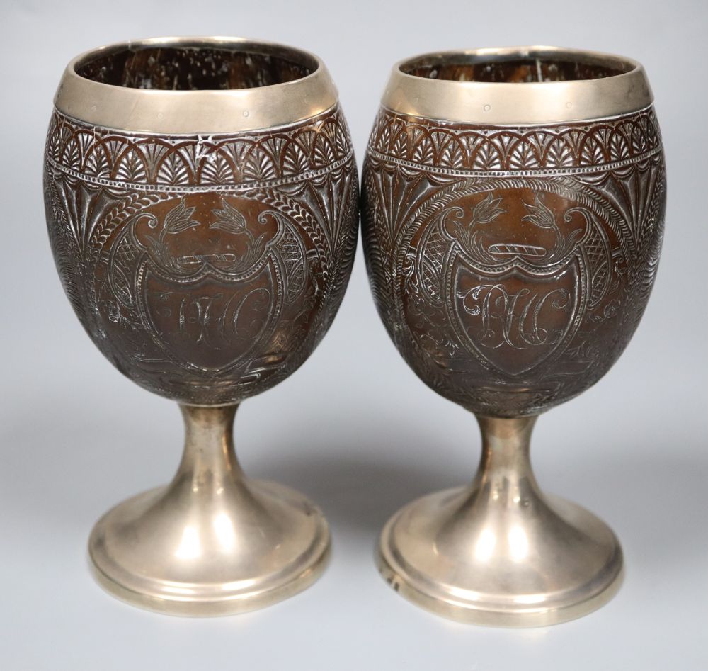 A pair of 19th century white metal mounted coconut cups, indistinct marks, 16.6cm.